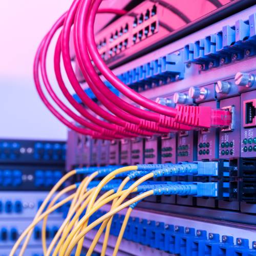 Close-up of fiber optic cables connected to a modern server rack.