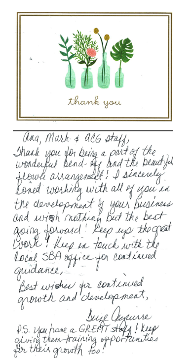A handwritten postcard with a heartfelt message placed on a modern office desk.