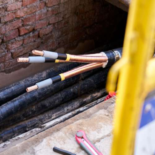 ACG technician installing armored fiber optic cable in trench.