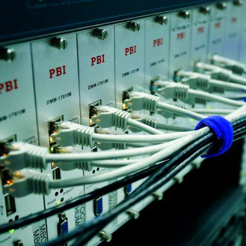 Field technician inspecting surge-protected telecom panel at a federal facility.